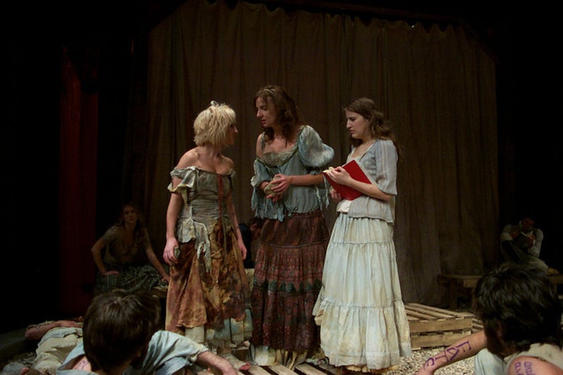 Three woman standing in dresses on stage