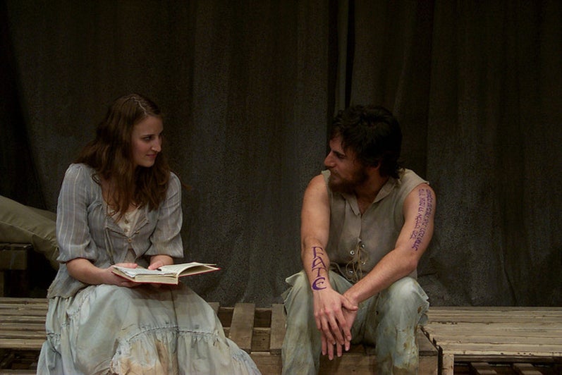 Man and woman holding a book sitting and talking