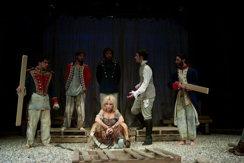 Group of people on stage with two men holding wooden planks