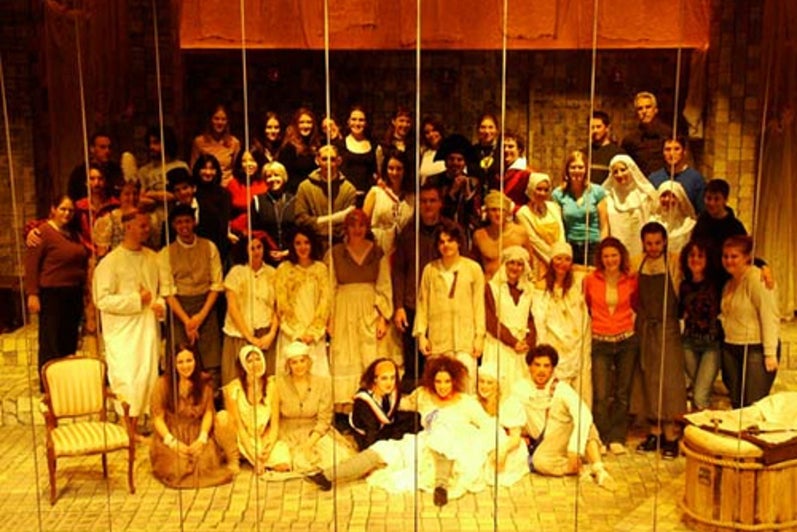 Cast of Marat/Sade posing for a photo on stage
