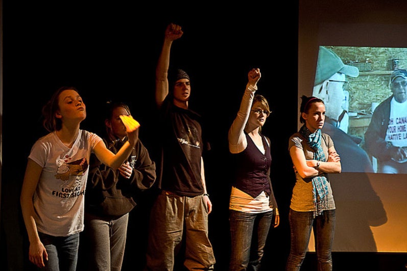 Five people standing and raising their fists in the play Differ/End: The Caledonia Project