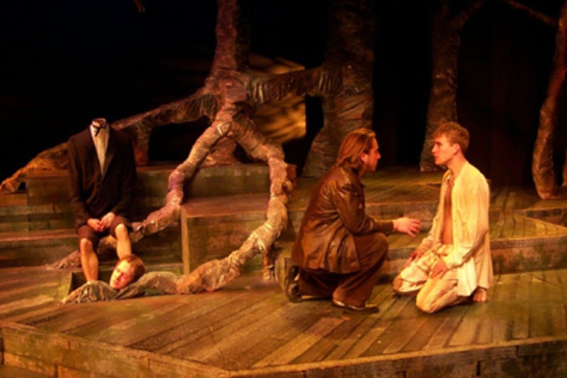 Two men talking to each other on their knees on forest-themed stage