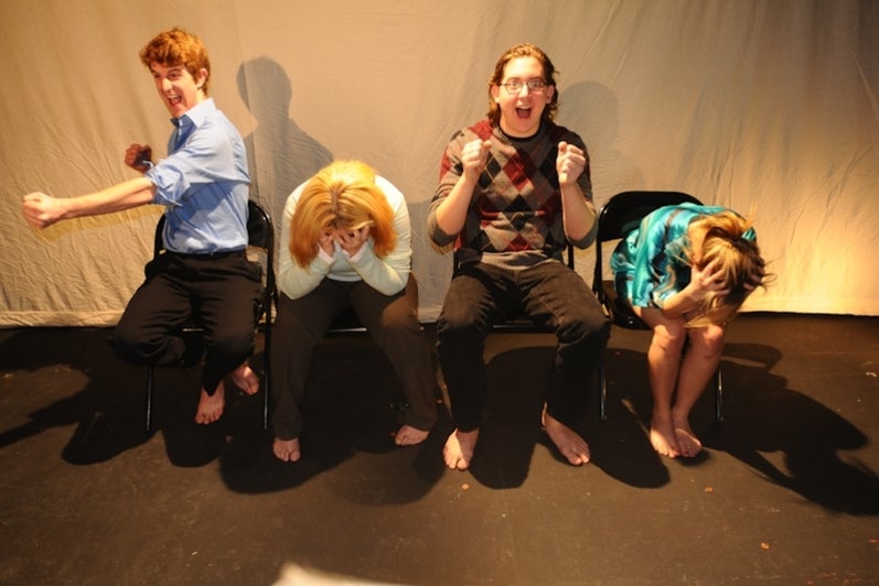 four excited people sitting in chairs.