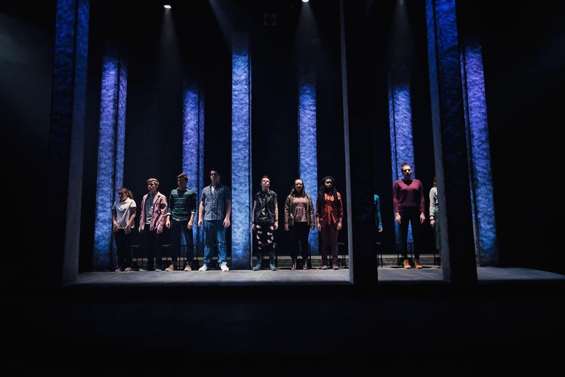 Full cast in a line onstage