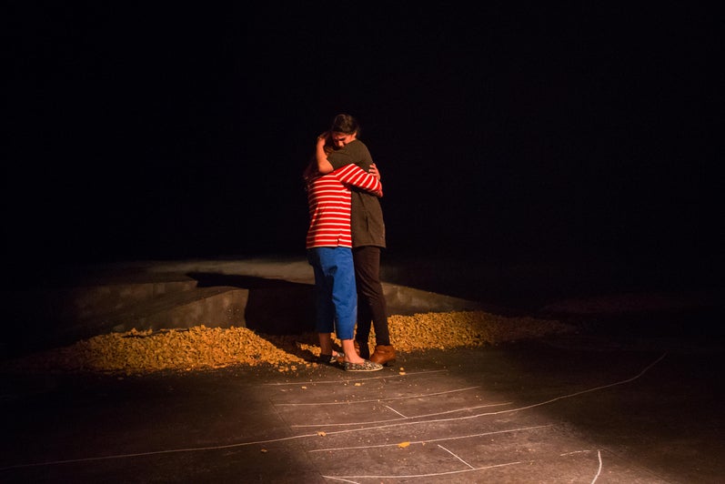 Two women hugging on a hopscotch grid