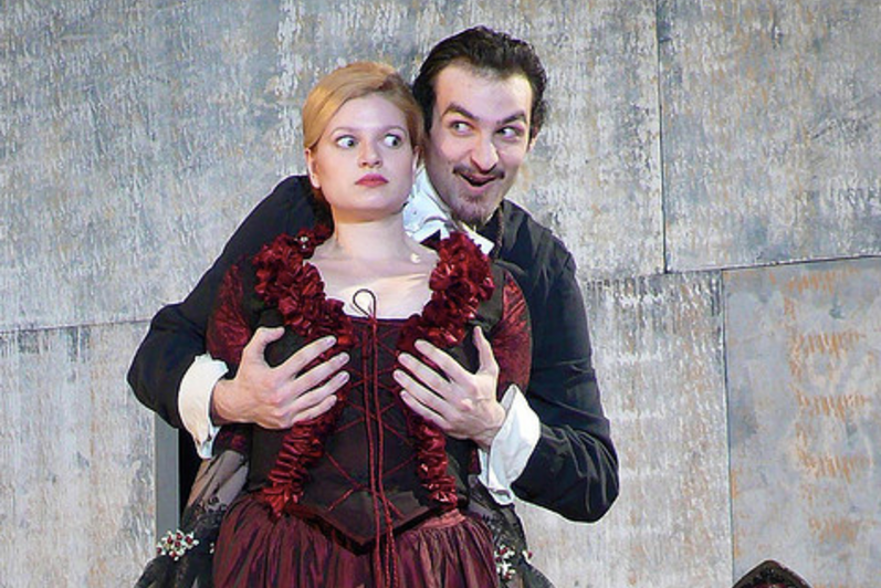 Man cupping a woman's breasts (in costumes) in the play Tartuffe