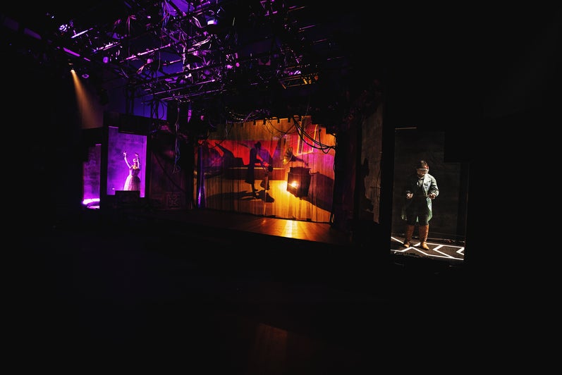 A wide shot of Ariana Nicholson as Iris and Ariana Kobetic as Woodnut, each in shadowboxes, in a scene from The Nether.