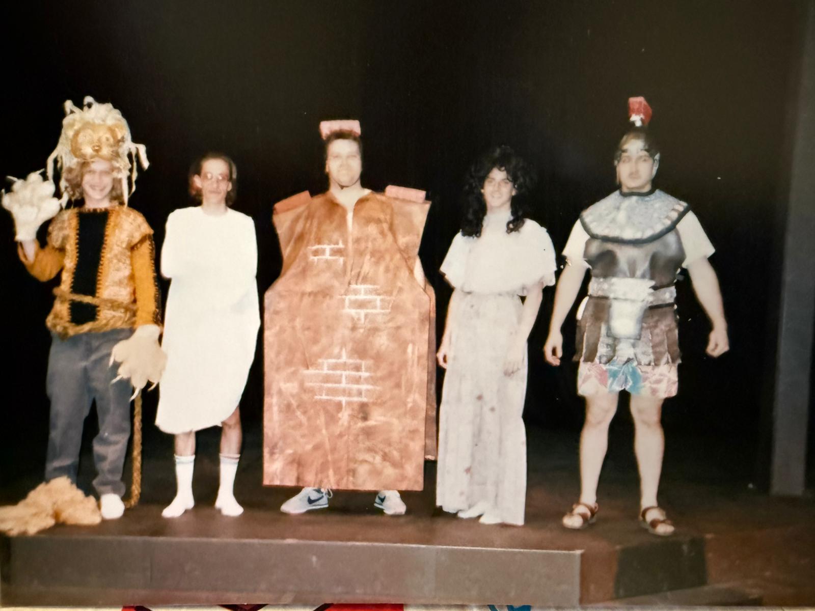 5 cast member standing together with costumes