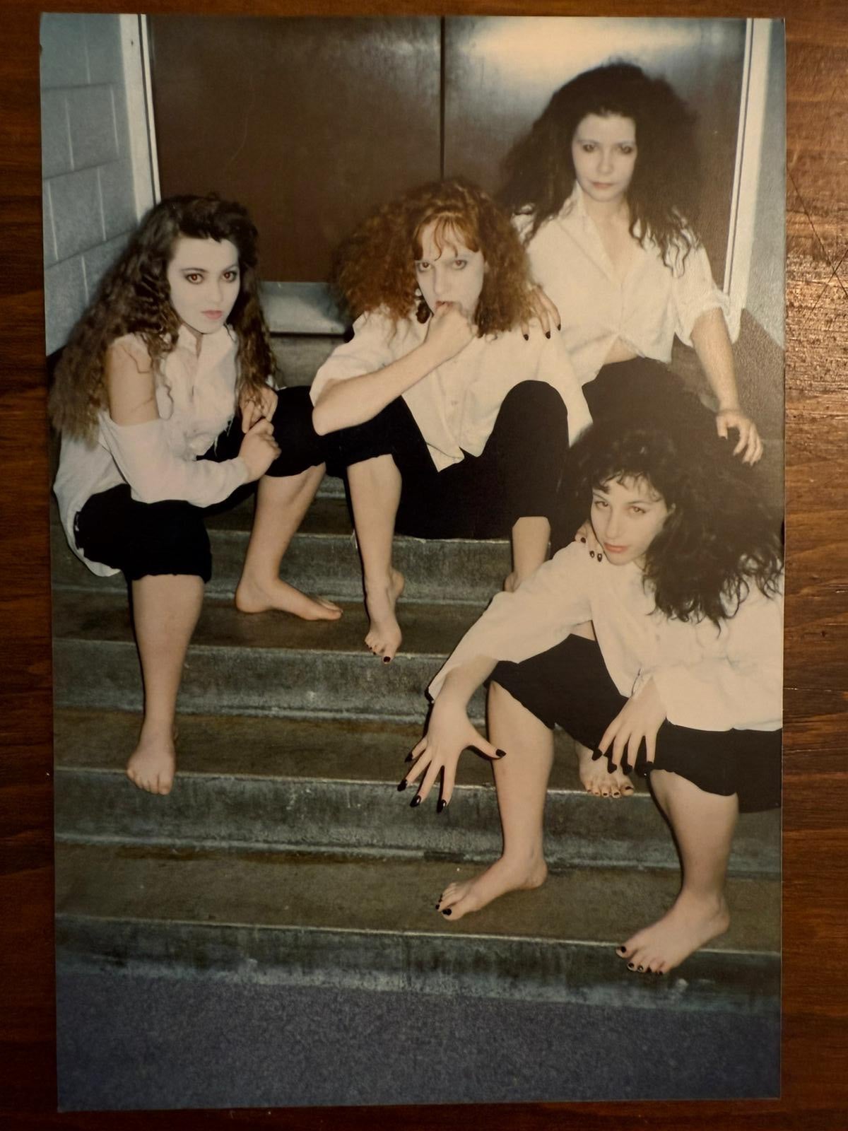 four women sitting together on stairs