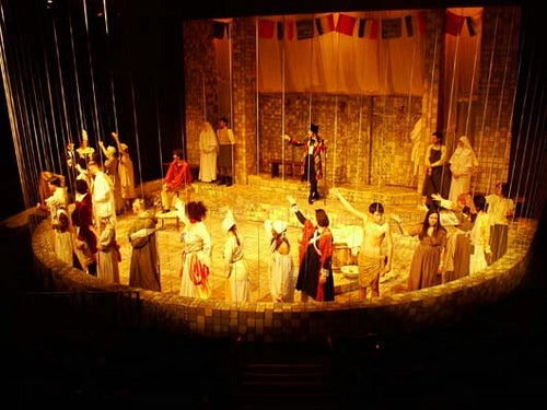 Cast of Marat/Sade standing on the edge of the stage