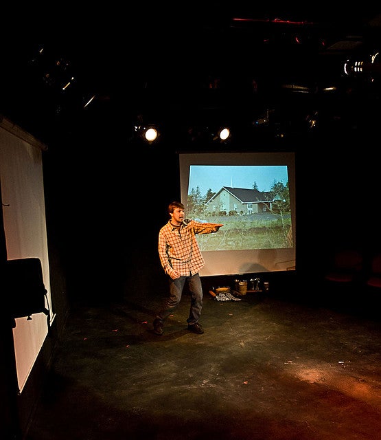 Man pointing out to the audience with a screen behind him