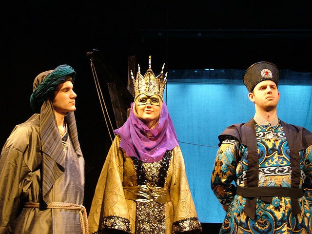 Three people standing in decorative costumes
