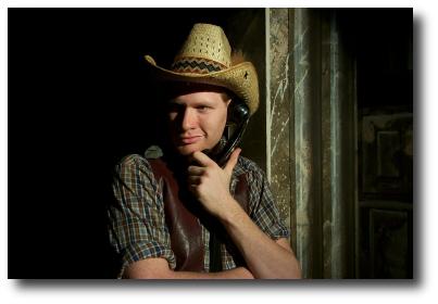 Man in a cowboy hat holding a phone to is ear
