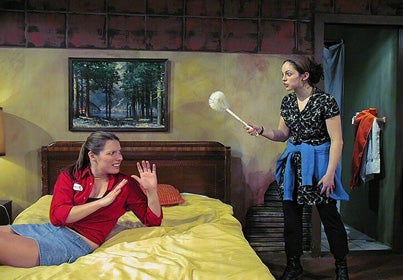 Woman threatening another woman on a bed with a dust brush