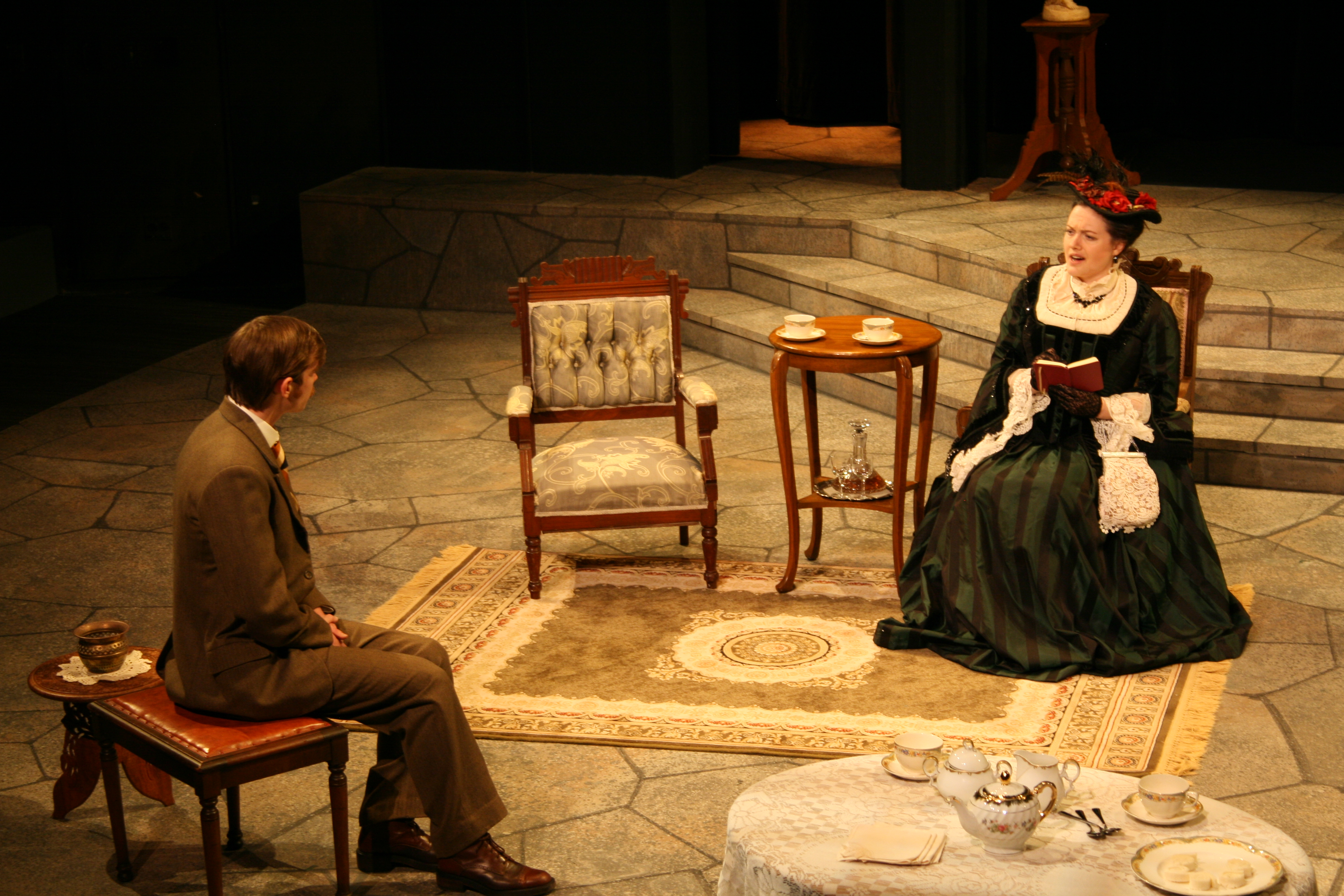 Woman in black dress sitting opposite a man in brown suit