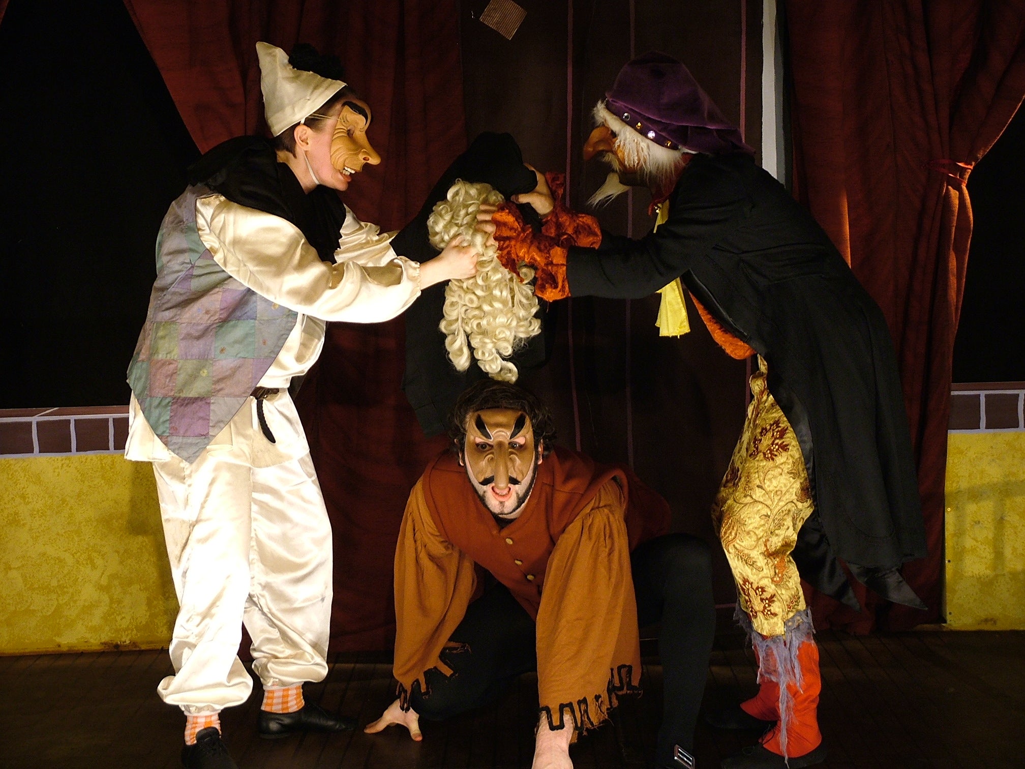 Actors in a group wearing masks on stage