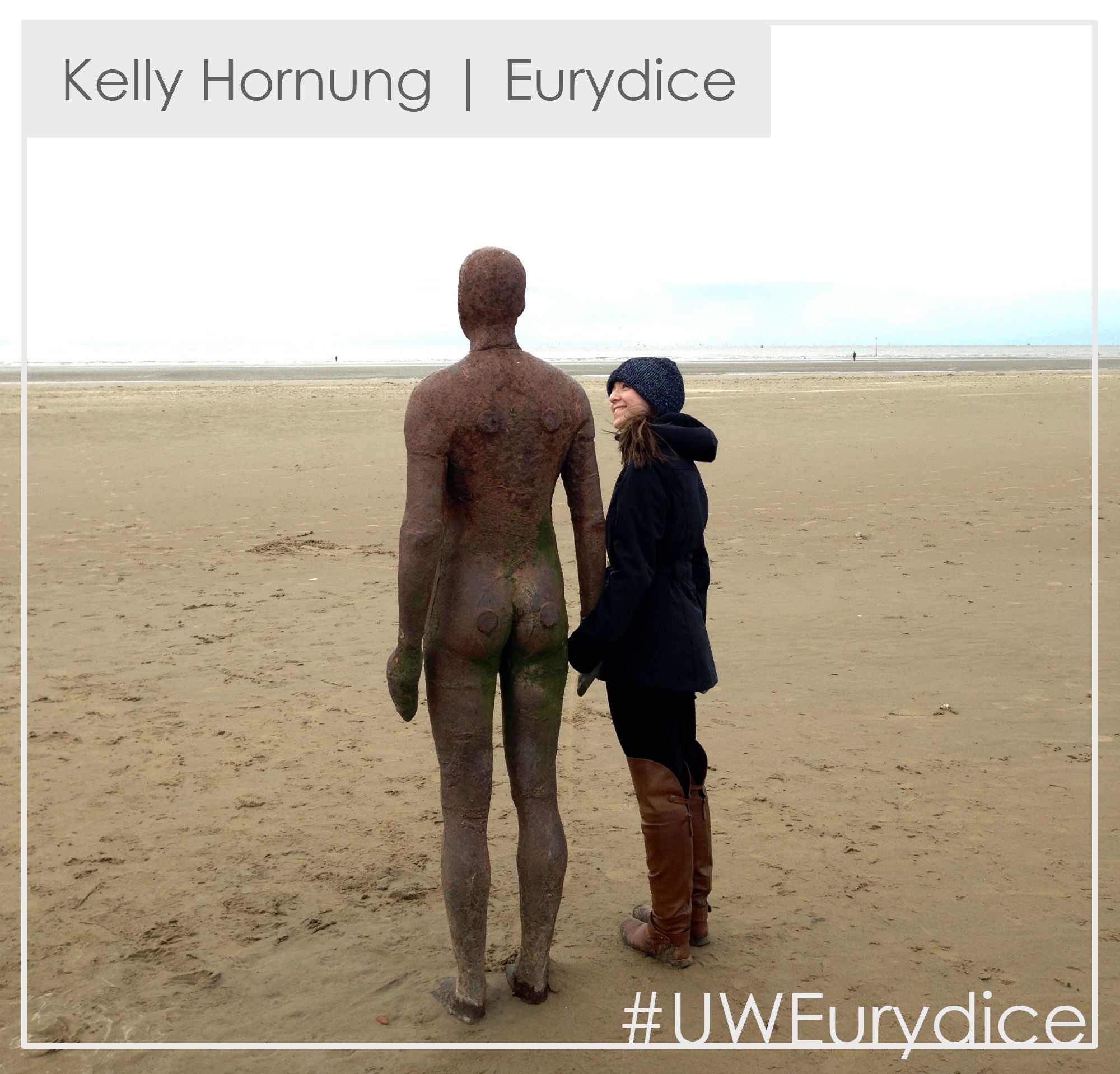 Photo of Kelly Hornung next to a statue on a beach