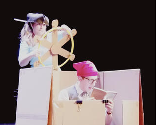 Justin and Olivia play with the boxes on stage
