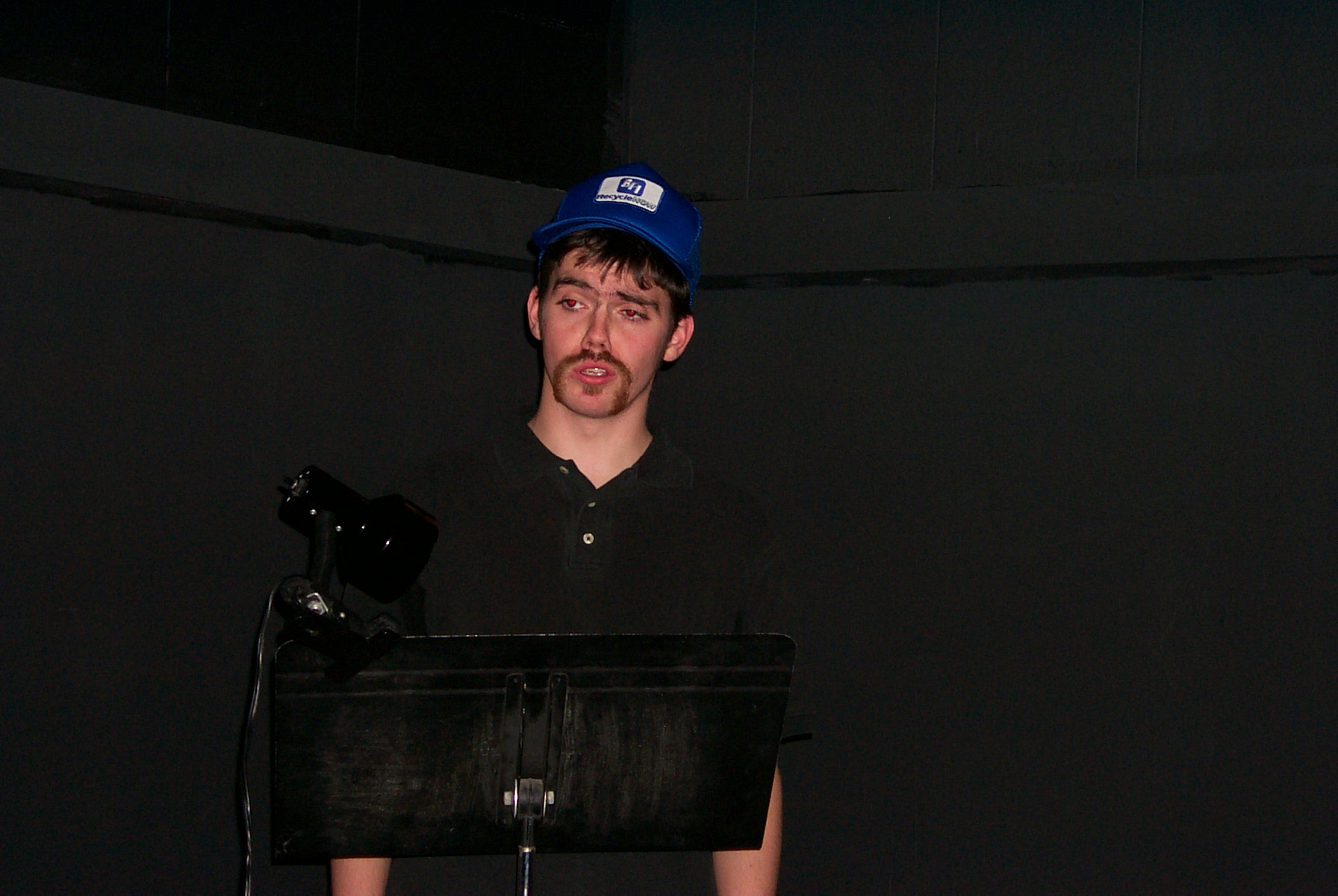 Man in blue hat with a sheet stand in front of him