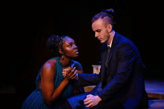 A woman kneeling on the ground holding a man's hand