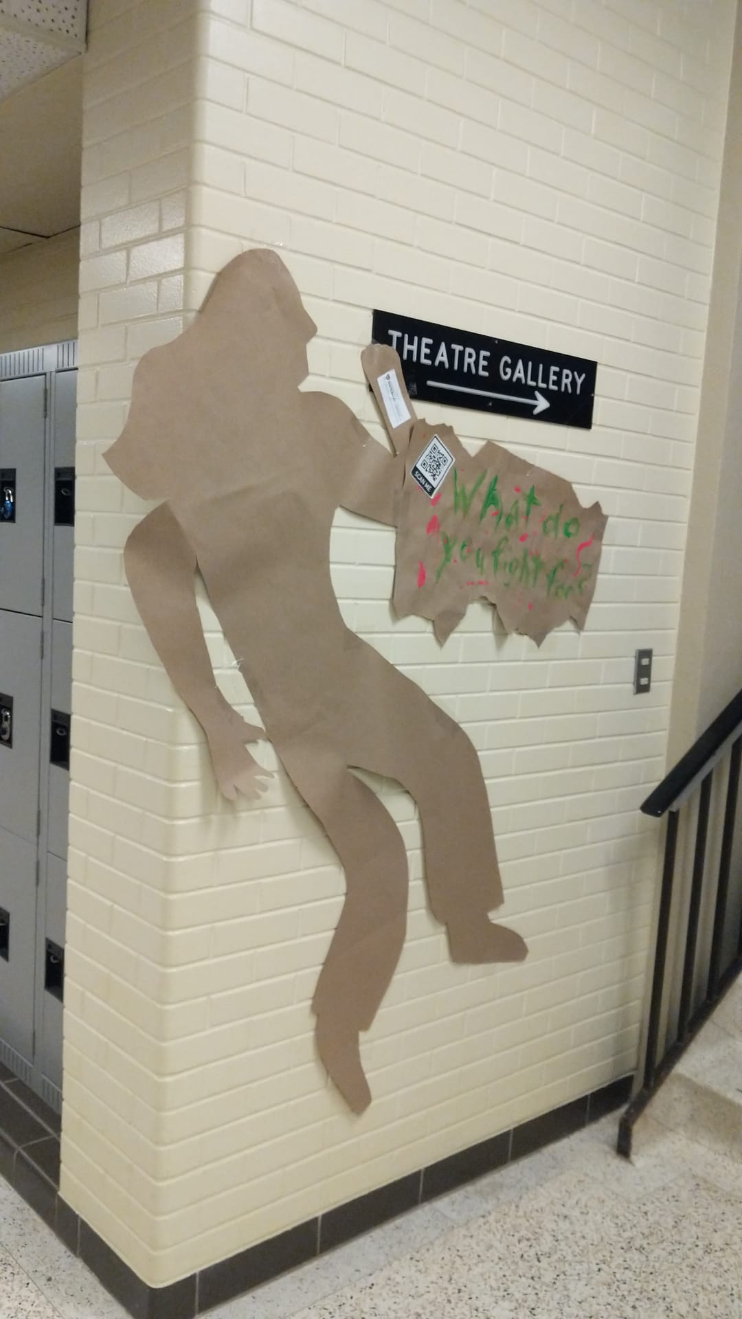 Photo of a cut out silhouette hung up on the wall near a sign for the Theatre Gallery