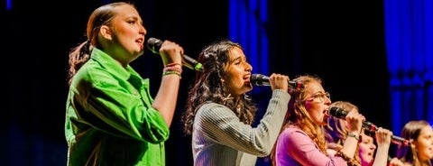 Girls in a line holding microphones