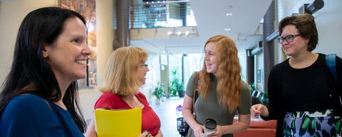 Students and professor talking in the Atrium