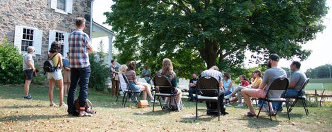 MTS students sitting outside the Brubacher House listening to a presenter