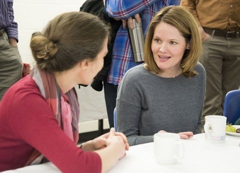 Student and faculty member in conversation over coffee.