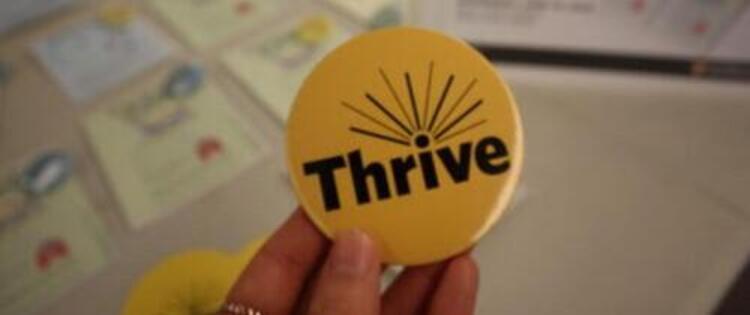 Thrive button in front of booth