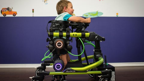 young child using a robotic exoskeletin to walk