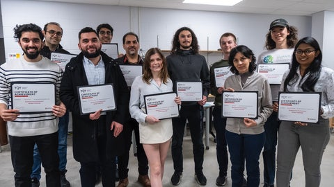 A group of people standing holding certificates.
