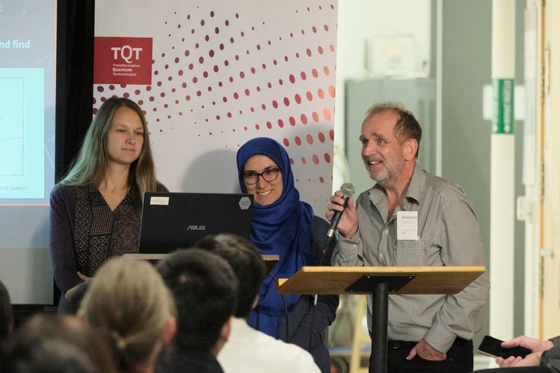 A group of people giving a presentation in front of a projector. 