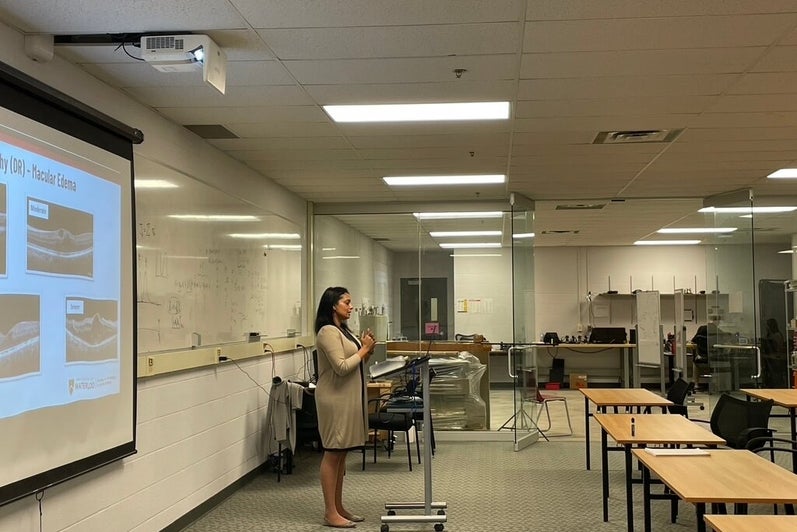 A person giving a presentation at the front of the room.