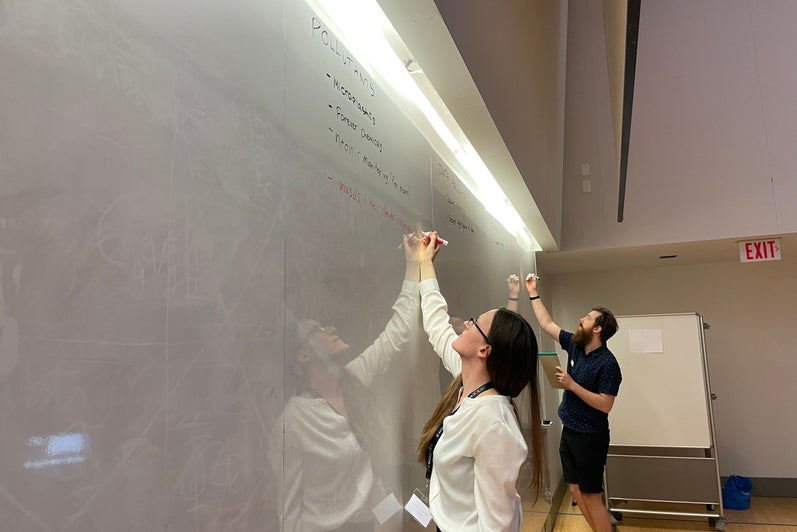 Person writing on a whiteboard.