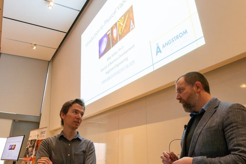 Two people talking in a lecture room