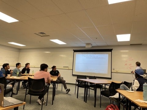 A person giving a presentation at the front of the room.