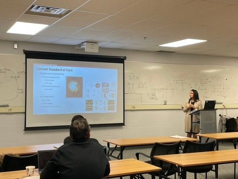 A person giving a presentation at the front of the room.