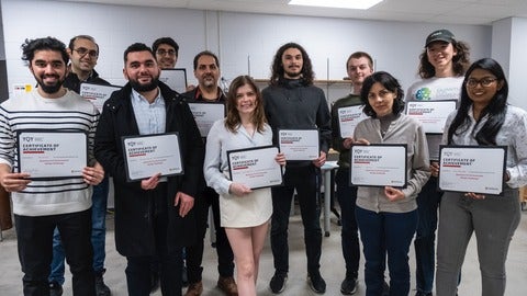 A group of people standing holding certificates.