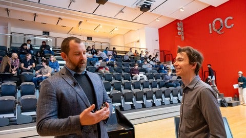 Two people talking in a lecture room