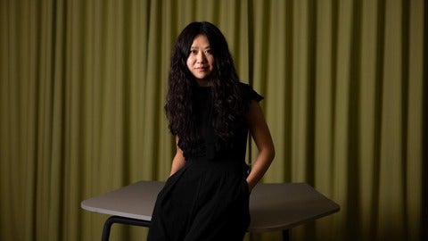 Lai-Tze Fan standing in front of a table 