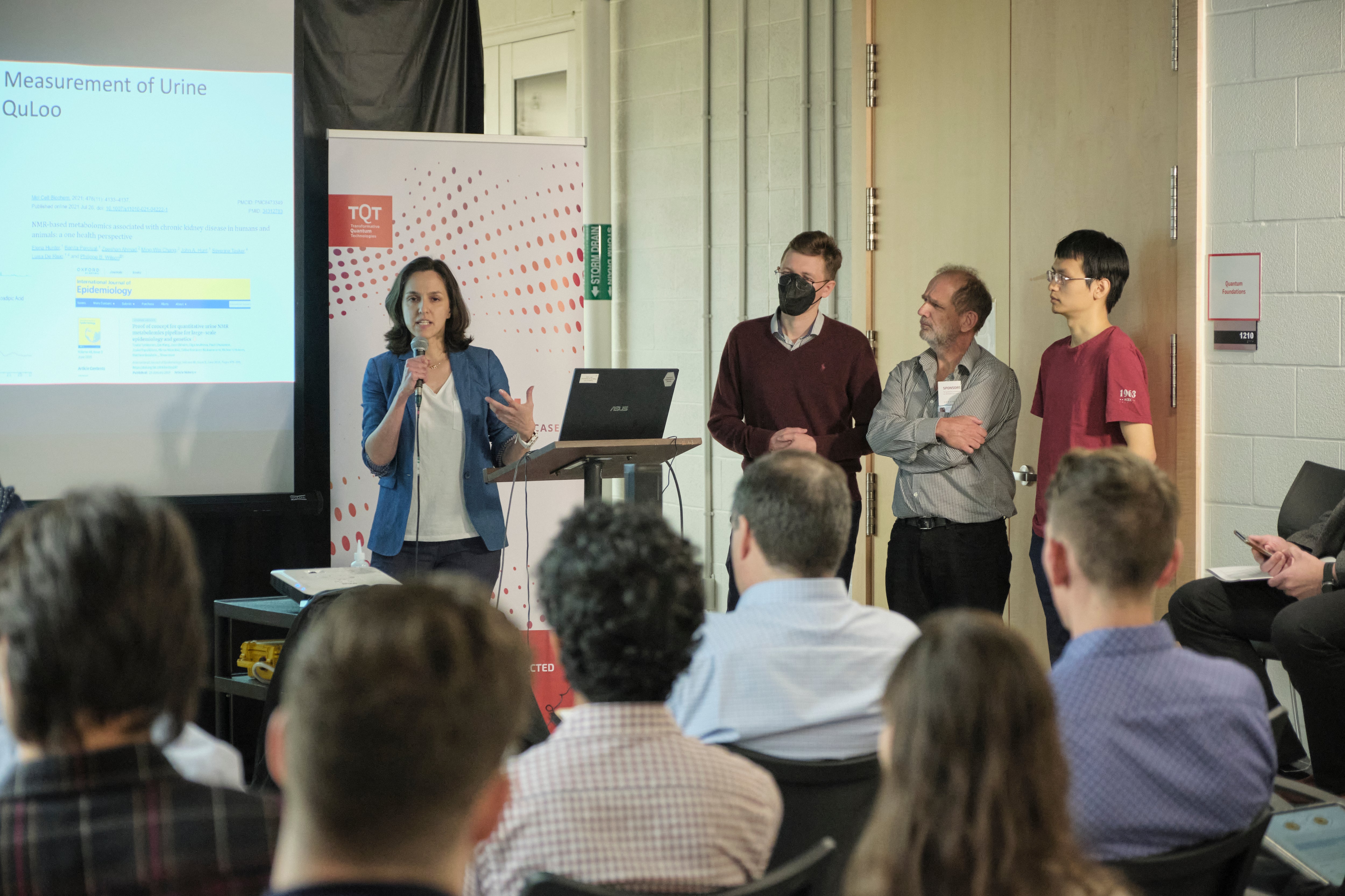A group of people giving a presentation in front of a projector. 