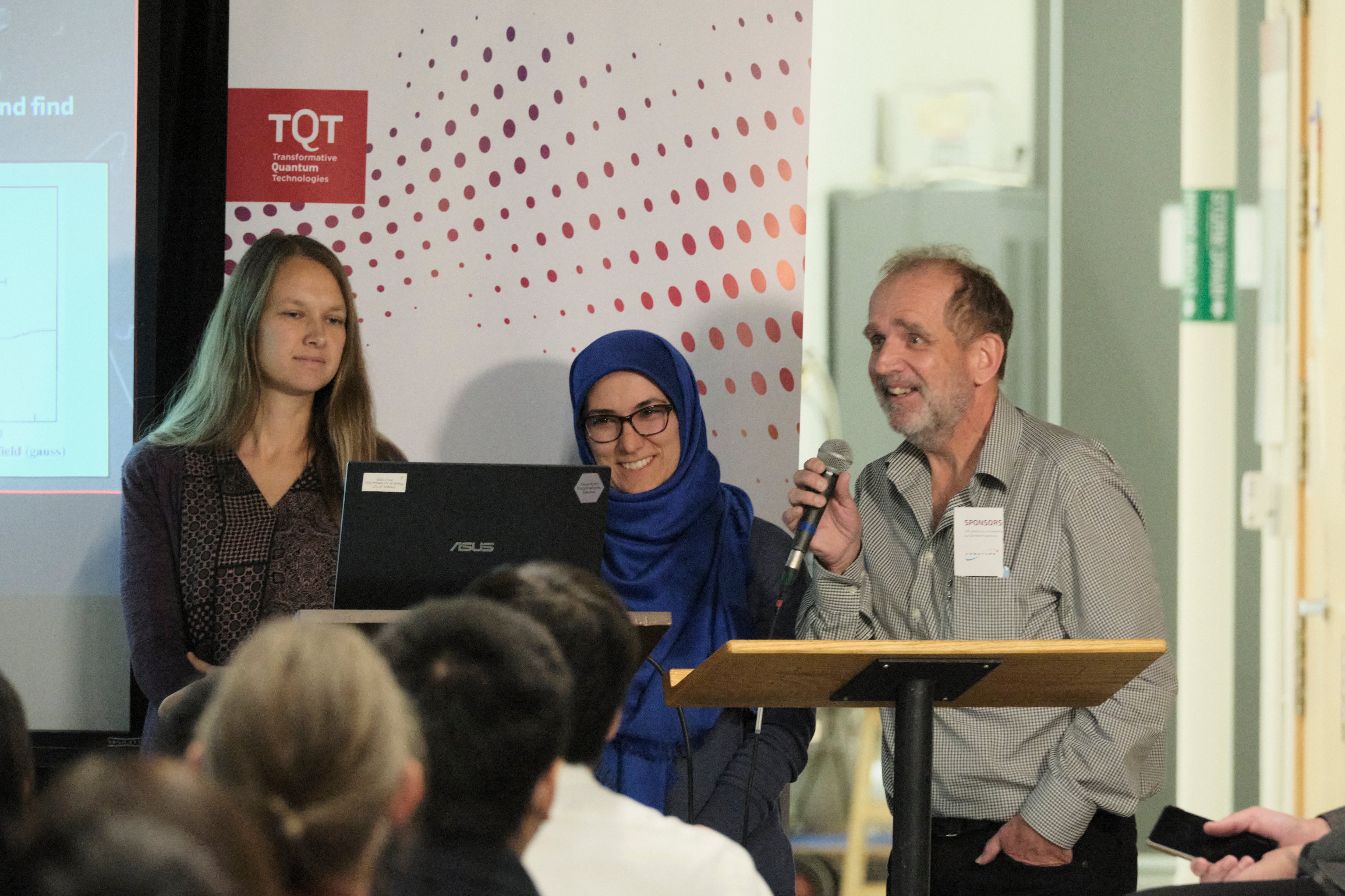 A group of people giving a presentation in front of a projector. 