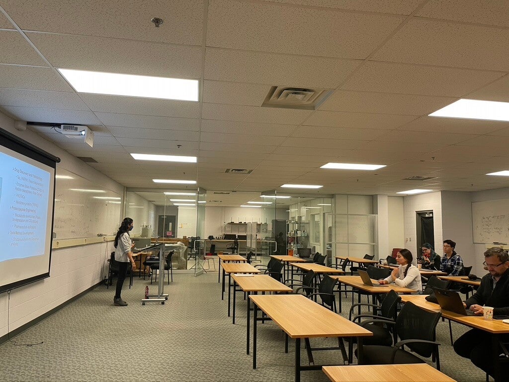 A person giving a presentation at the front of the room.