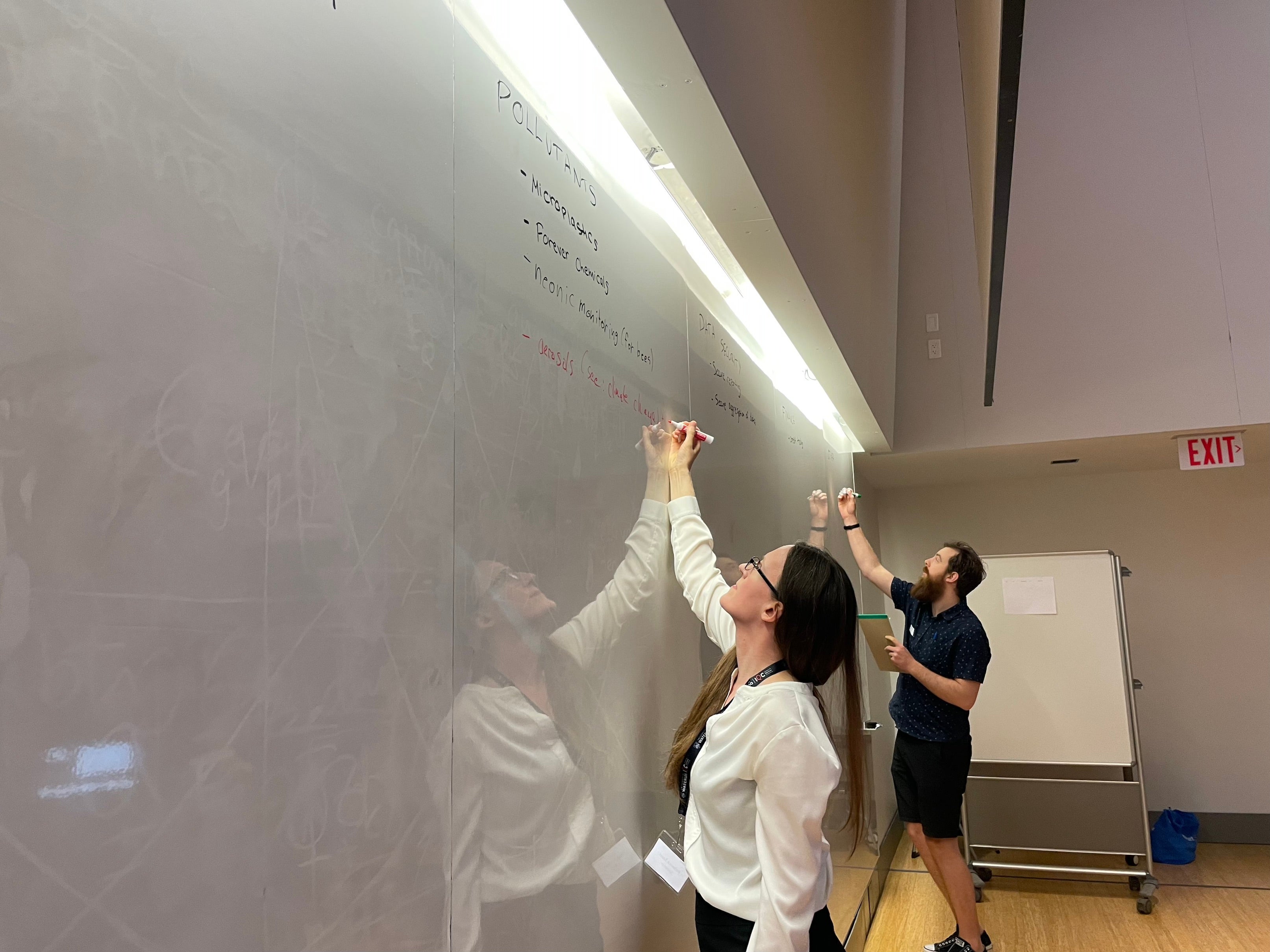 Person writing on a whiteboard.