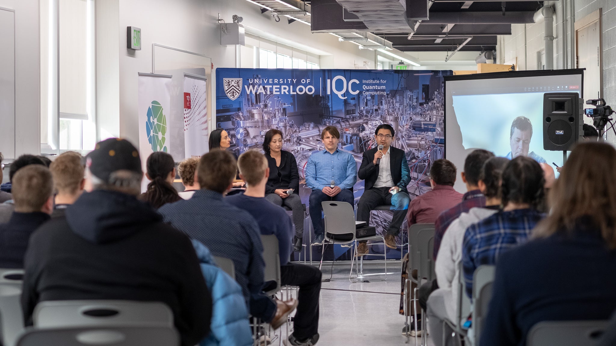 A group of panelists speaking to a room of people. 