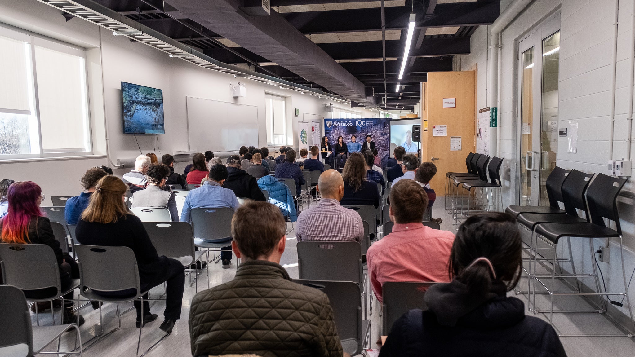 A group of panelists speaking to a room of people. 