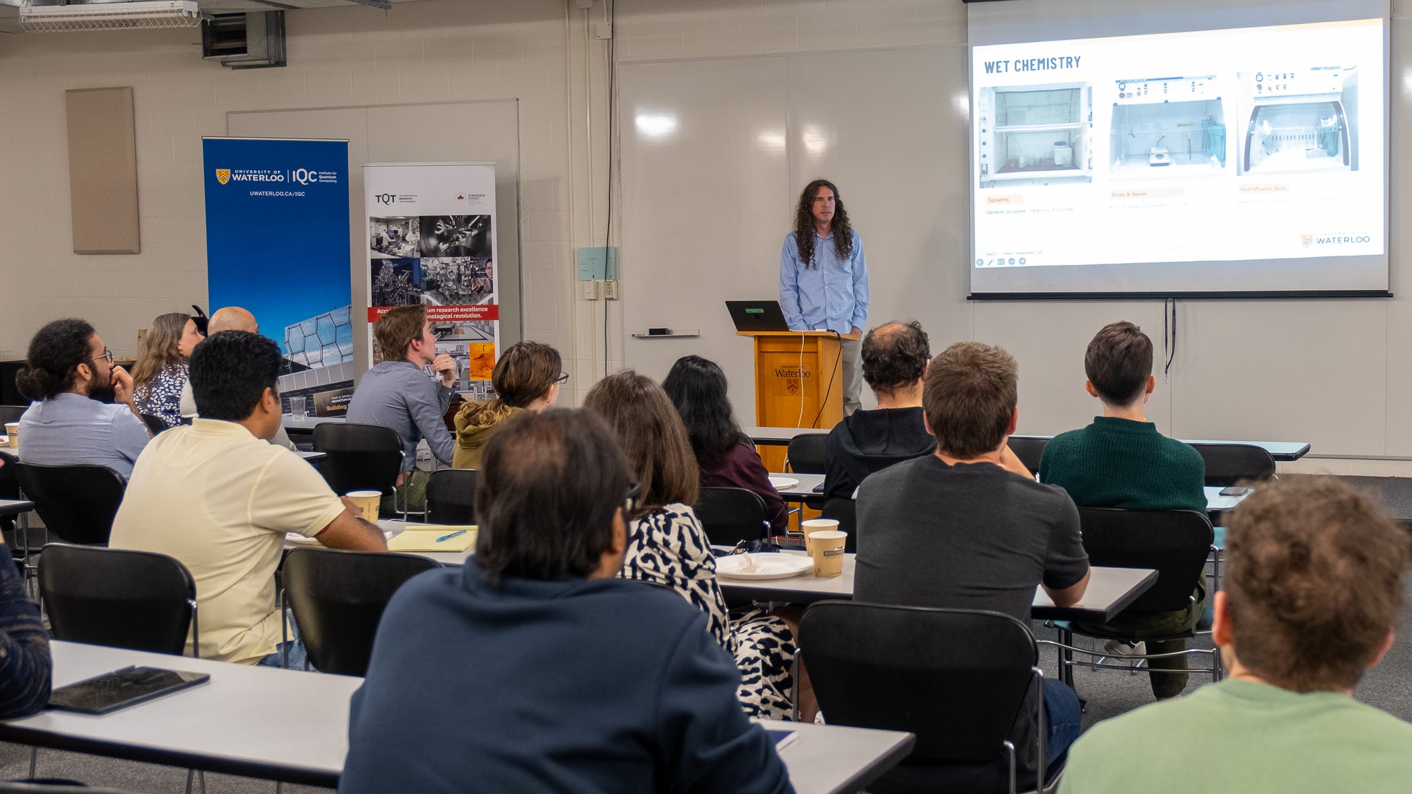 John Nugent in front of a projector screen.