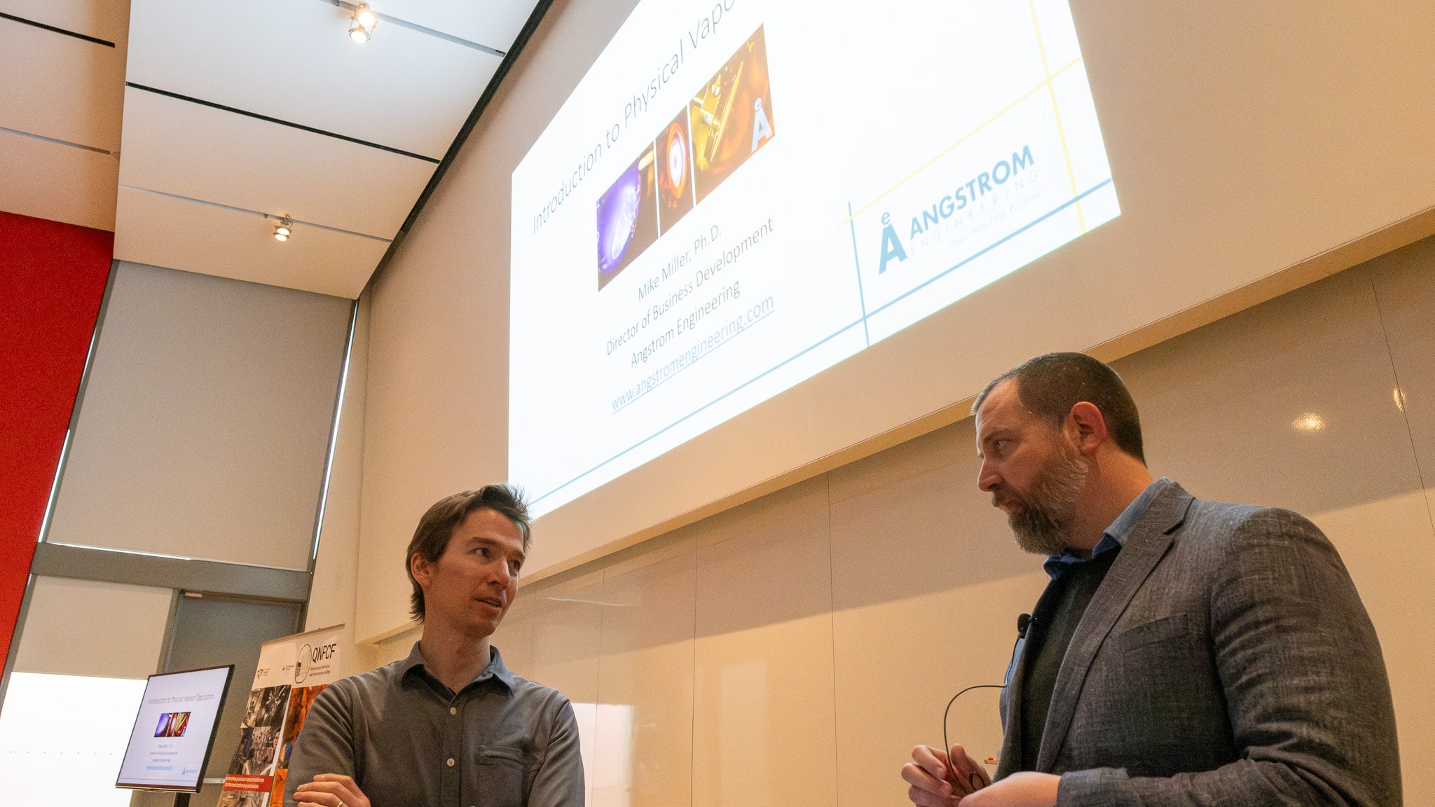 Two people talking in a lecture room