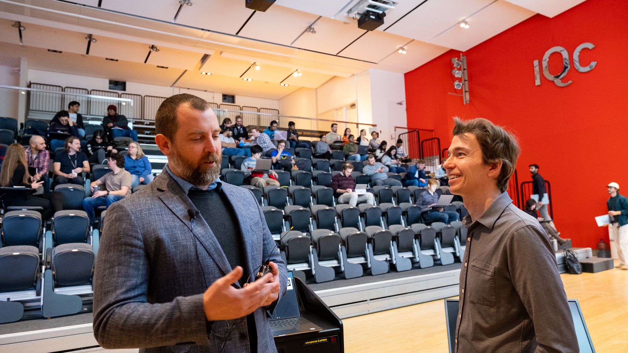 Two people talking in a lecture room